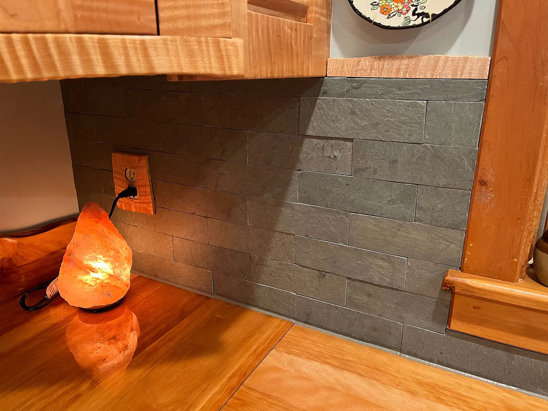 Wooden cabinet with a salt lamp and slate wall in a room setting